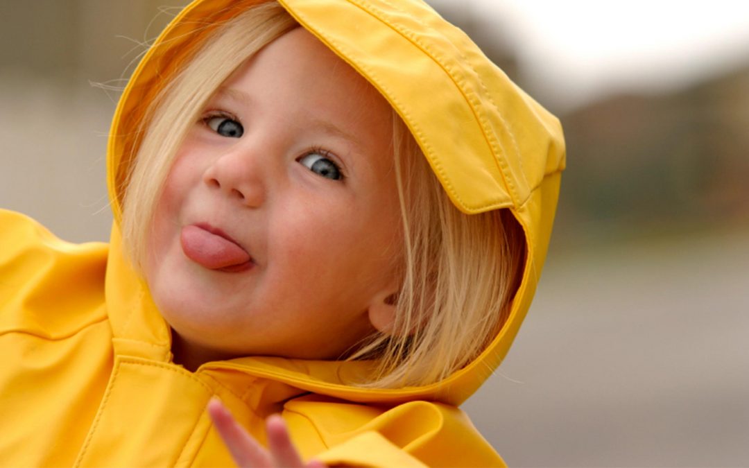 Ein fröhliches Kind, das eine gelbe Regenjacke trägt – Kindergarten in Düsseldorf